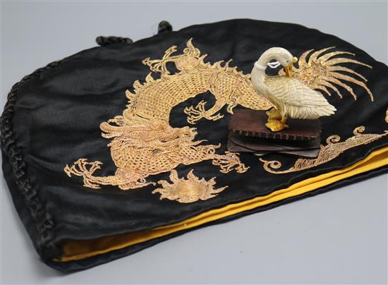 A carved ivory duck on stand and dragon embroidered tea cosy